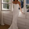 bride in strapless lace wedding gown standing by window