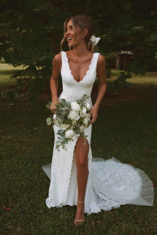 bride wearing sleeveless lace wedding gown with low back and train