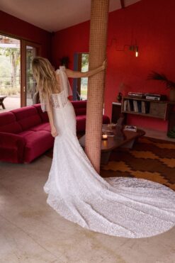Side profile of embellished mermaid wedding gown with flowing train