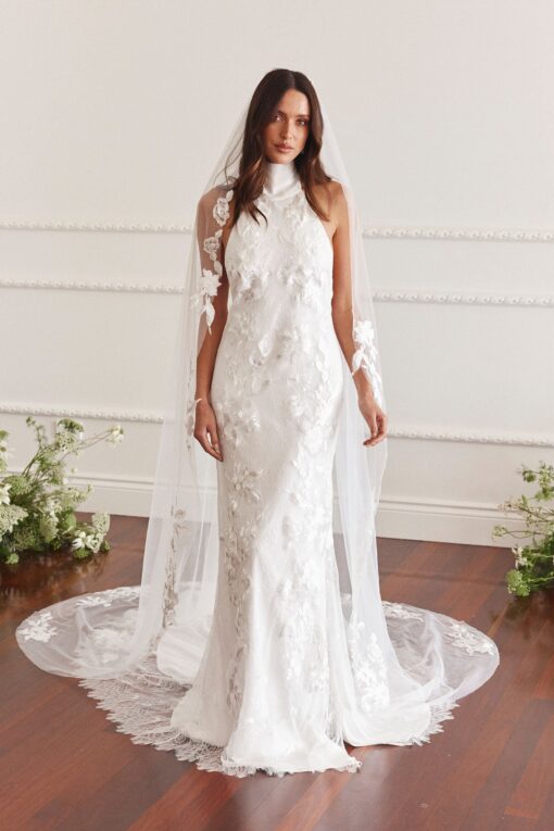 Bride standing in lace wedding gown with chapel train