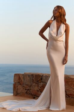 Satin halter backless wedding dress with cowl neckline at sunset