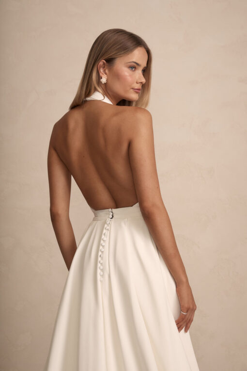 Bride in high-neck sheath wedding dress with open back